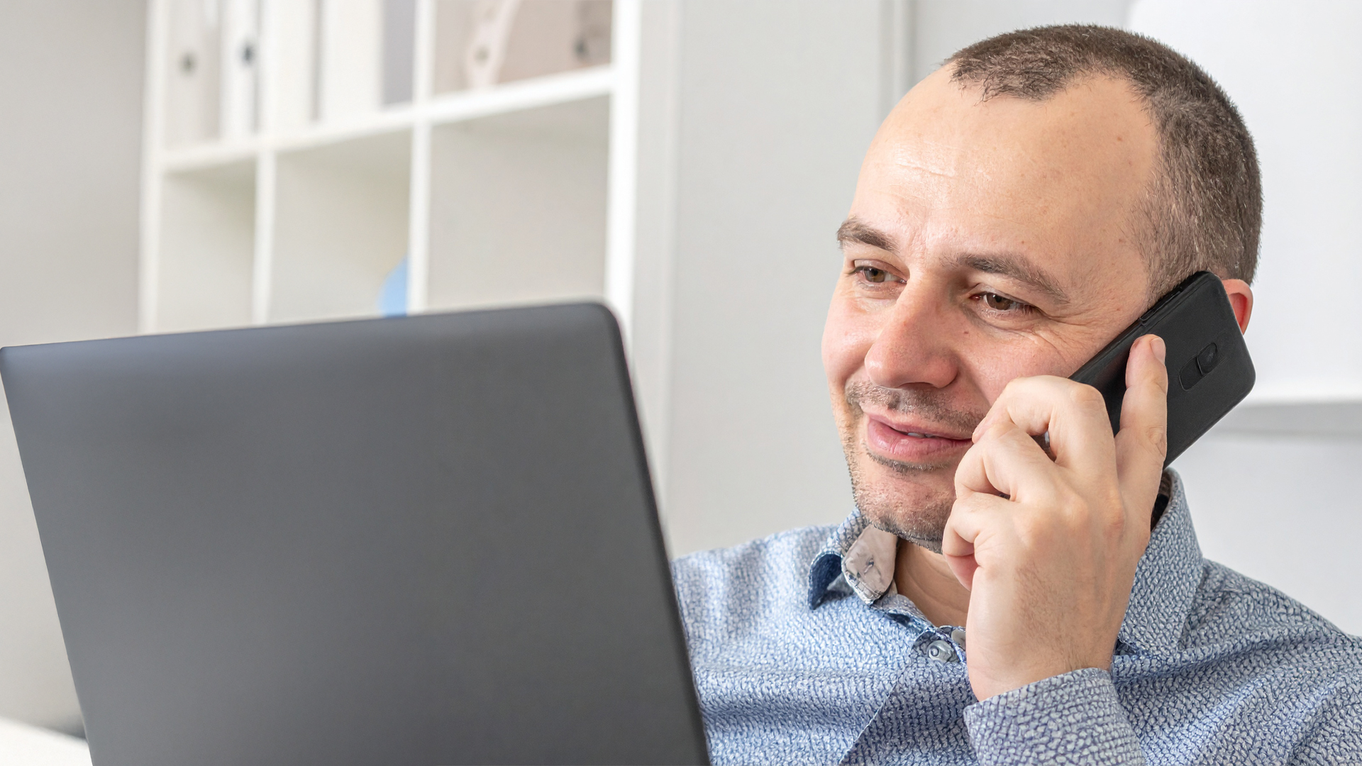 Professional speaking by phone while working at a laptop